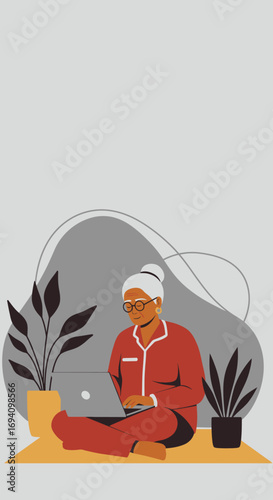 A senior woman in pajamas sits comfortably using a laptop at home, surrounded by houseplants. Represents remote work, learning, or leisure for older adults.