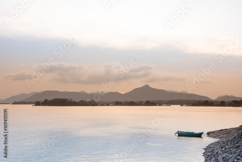 Sunset photograph of Gal Oya reservoir with a boat moored at the banks.