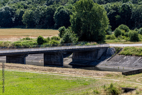 Fototapeta Naklejka Na Ścianę i Meble -  Bridge over the dam on Lake Mitkow with Mount Sleza in the background in Poland