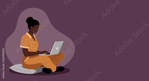 Young Black woman working on a laptop from home, sitting comfortably on a cushion. Represents remote work, flexible lifestyle, or online learning and productivity.