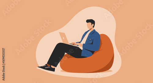 Young man comfortably working on his laptop while sitting on a beanbag chair, depicting remote work, flexible hours, and modern lifestyle.