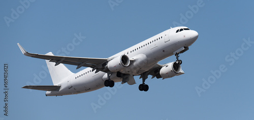 Airplane take off on the blue sky, Aircraft flying on sky background. White passenger jet plane in the blue sky. Low angle view of Airplane flying under blue sky