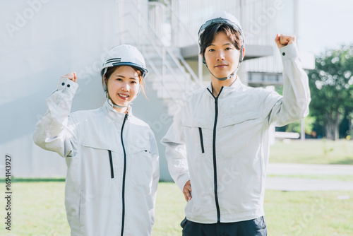 ヘルメットを被って外で作業着を着て仕事する男女
Men and women wearing helmets and work clothes outside