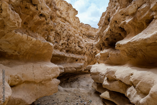 View of the stark, sun-baked canyon walls rise dramatically, carved by time and weather in Wadi Degla Protectorate, Cairo, Cairo Governorate, Egypt.