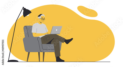 Relaxed senior man actively uses a laptop in a comfortable armchair at home. Represents digital literacy, remote work, and modern independent living for older adults.