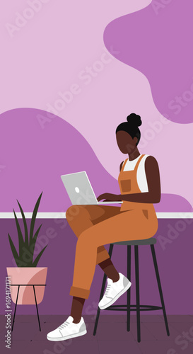 Focused woman in overalls using laptop on a stool, representing modern remote work, freelance, and digital productivity. Ideal for lifestyle, business, and technology content.