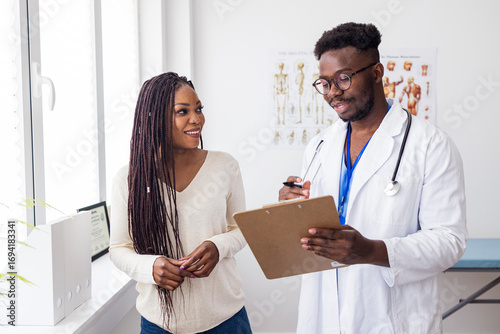 Photos Smiling Doctor Consulting Patient in Bright Medical Office