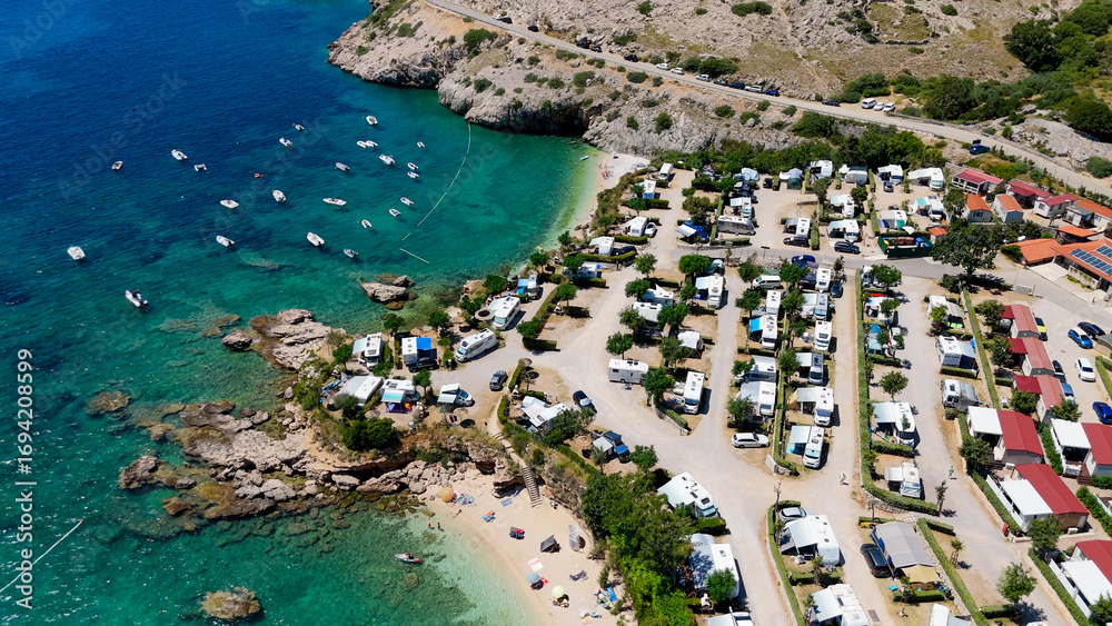 Fototapeta premium Campsite at Campig Skrila, Krk Island, Stara Baska Croatia, Aerial View of the Mountains and Coast With Boats, Beaches and Adriatic Sea. The Seaside Rv Campmobiles on a Summer Beautiful Coastline