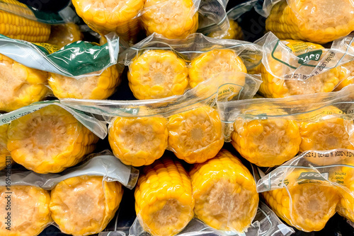 Corn cobs pack in basket at grocery store, fruits and vegetables sold at market