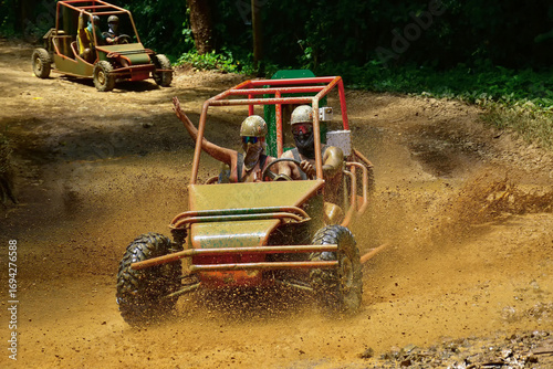 Foto Tourists are enjoying a thrilling buggy adventure on a muddy road in punta cana,