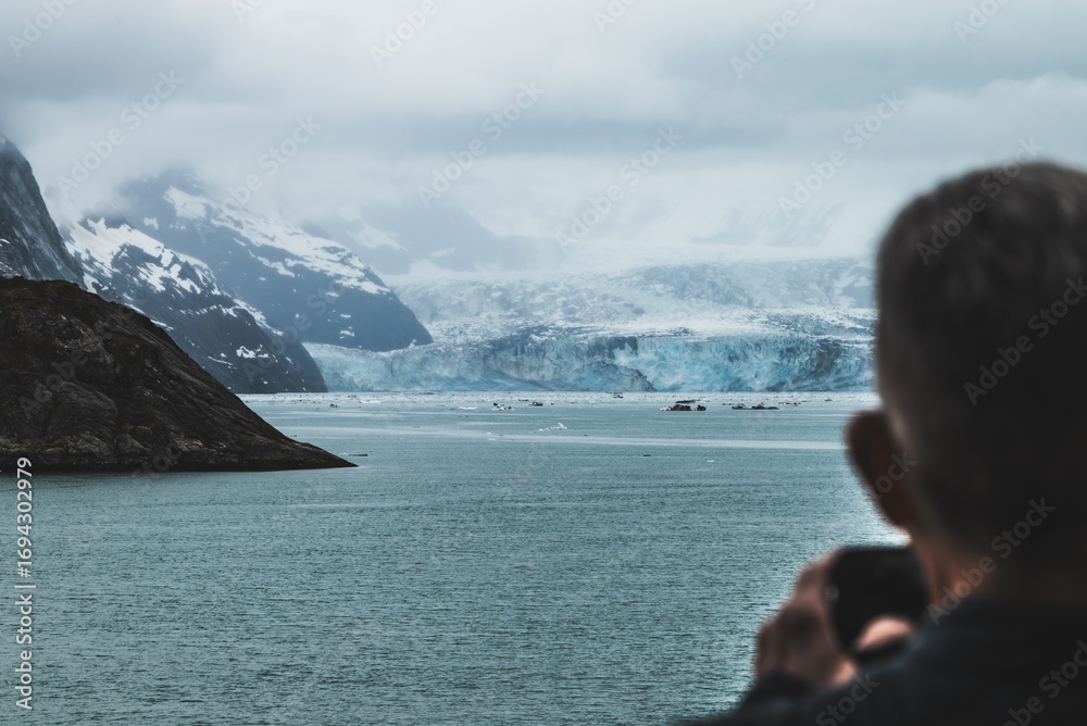 Fototapeta premium Close up view on the glaciers in Alaska, mountains and glacier landscape. Man taking photo of the glacier