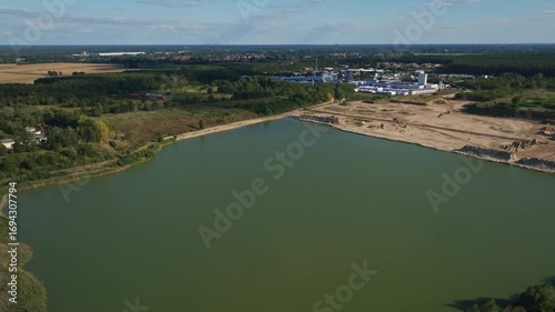 Aerial drone view of quarry lake and sand mining area with industrial factory in Oranienburg, Brandenburg, Germany