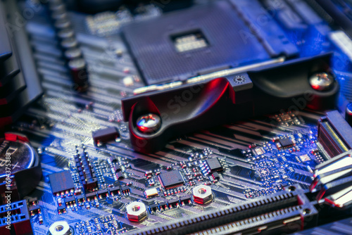 Motherboard of powerful PC with AM4 CPU Socket. Computer hardware chipset components close-up in blue light