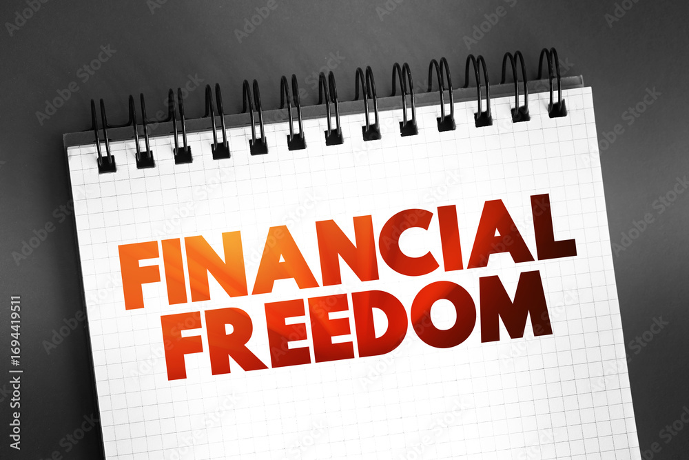 Fototapeta premium Financial freedom - having enough savings, financial investments, and cash on hand to afford the kind of life we desire for our families, text on notepad, concept background