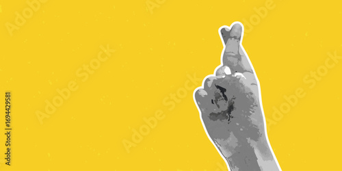 Hand with crossed fingers against a bright yellow textured background symbolizing hope and good luck