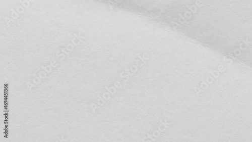 Close up of a crumpled piece of white paper showing texture and subtle shadows across the surface