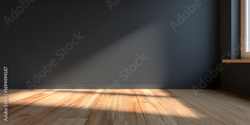 Sunlight streams across a modern empty room with warm wooden floors and dark walls