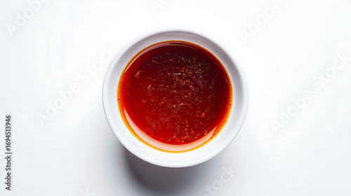 Overhead shot of a white bowl filled with a vibrant red liquid sauce