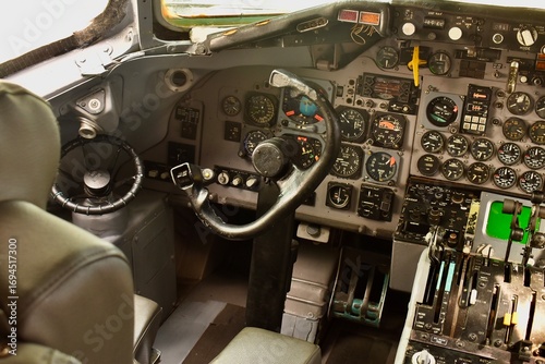 Foto Modern airplane cockpit interior with active flight instruments and illuminated control panels during flight