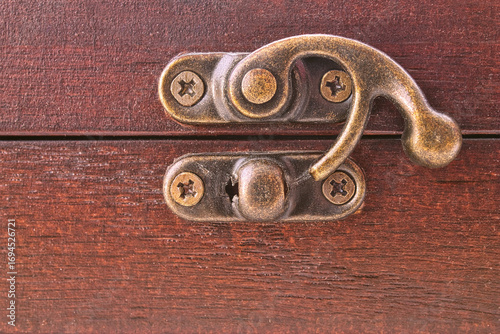 Close-up of an antique bronze latch on a vintage wooden treasure chest. Concept of mystery, secrets, adventure, and valuable keepsakes.