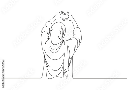 Woman in hijab making a heart shape with her hands