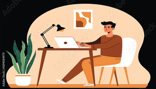 Young man working on laptop at desk in a home office