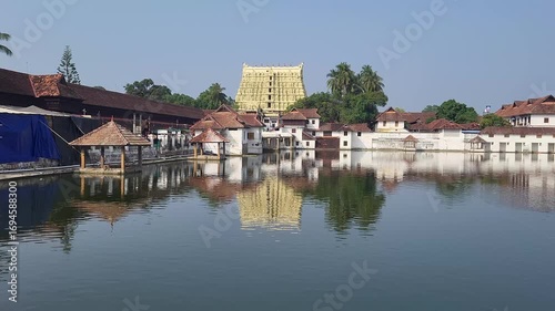 A picturesque lake surrounded by calm waters, with the magnificent Padmanabha Swamy Temple rising elegantly on the shore