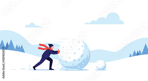 A person rolling a giant snowball down a snowy hill in the winter season
