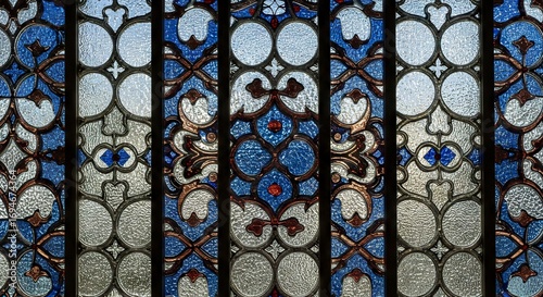 Stained glass window with geometric patterns in blue white and brown