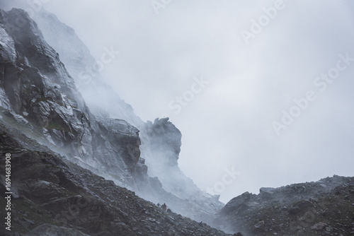 Photography Rocky mountain formation landscape of boulder zone engulfed in clouds near steep climb of ridge Hampta pass trekking trail located at altitude of 4270m which is a dramatic crossover trek