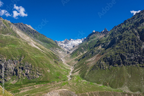 Panoramic view of glacial u-shaped valley having snow cladded peaks, glaciers and moraines  deposited by glacier in high altitude Himalayas mountain region of Himachal Pradesh, India.