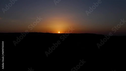 vue sur un coucher de soleil avec des éoliennes