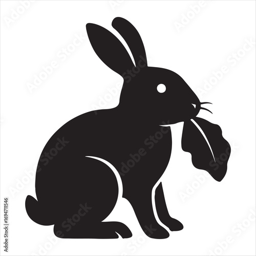 Silhouette of a rabbit with large ears holding a leafy green plant in its mouth