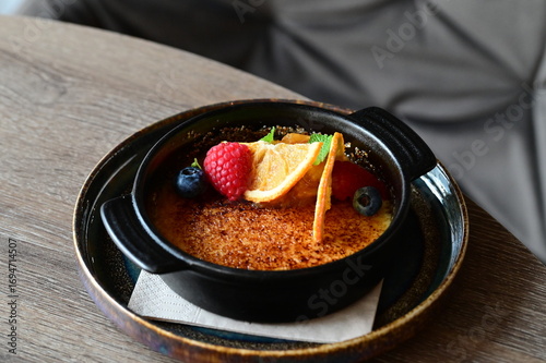 Obraz na plátně crème brûlée served with fresh fruits on a grey background.
