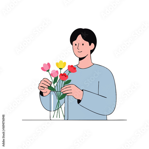 Young man arranging vibrant flowers in a clear vase, bringing joy and freshness indoors