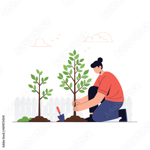 Gardener planting a small tree in the garden with a trowel during spring