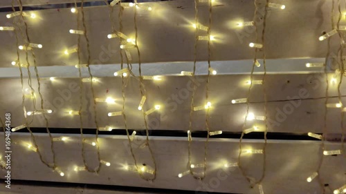 Glowing string lights illuminate decorative wooden wall display in warm festive ambiance.
