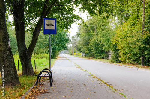 Rural bus stop with bench and sign in Masovian countryside, Poland