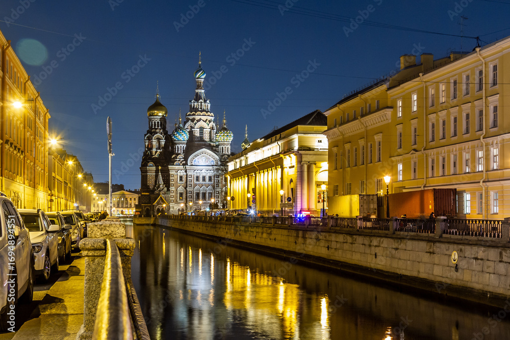 Obraz premium Night perspective view of Griboyedov Canal with illuminated Savior on Spilled Blood church reflection in water. Classic Saint Petersburg atmosphere. Saint Petersburg, Russia 