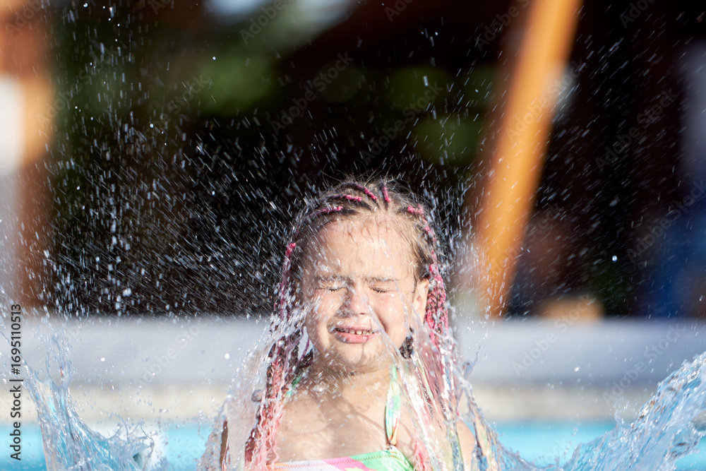 Obraz premium Joyful moments of a girl playing in water