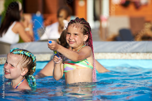 Wallpaper Mural Little girl enjoys water play in the pool Torontodigital.ca