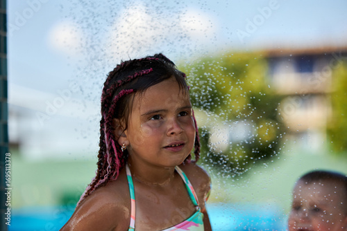 Girl enjoying water play at summer pool