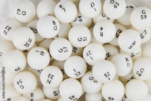 White bingo lottery balls with black numbers close-up on a white background