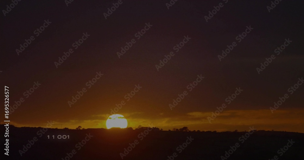 Obraz premium Sinking sun disc glowing over hills at rural landscape, showing silhouetted shrubs, numeric 11 001