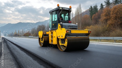 Heavy yellow road roller compacting fresh asphalt on a highway construction site under a cloudy sky, showcasing infrastructure development and urban expansion