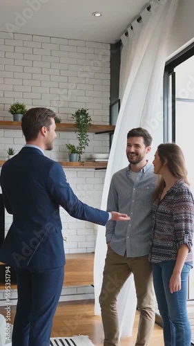 vertical. Real estate agent showing modern apartment interior to smiling young couple. Studio business photo of property consultation and home viewing. Real estate and housing market concept. Design f