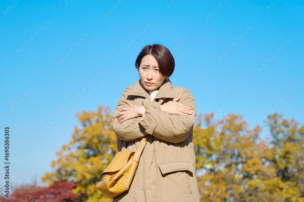 Fototapeta premium 外で凍えるミドルエイジの女性