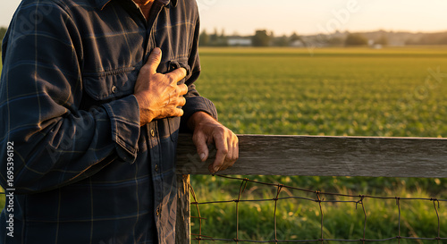 Rural man clutching chest in pain, possible heart attack, in golden hour field
