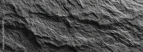 Panel kuchenny z motywem Close-up shot of a dark, textured rock face with deep crevices and ridges, offering a rugged and natural background texture