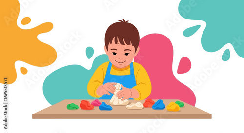 A happy boy enjoys playing with colorful clay dough on table, creative child